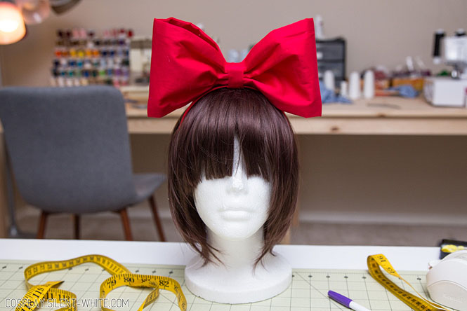 Red bow on a brown wig and wig head
