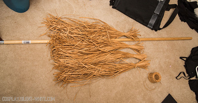 4 bundles of raffia paper ribbon on the floor with a broom stick